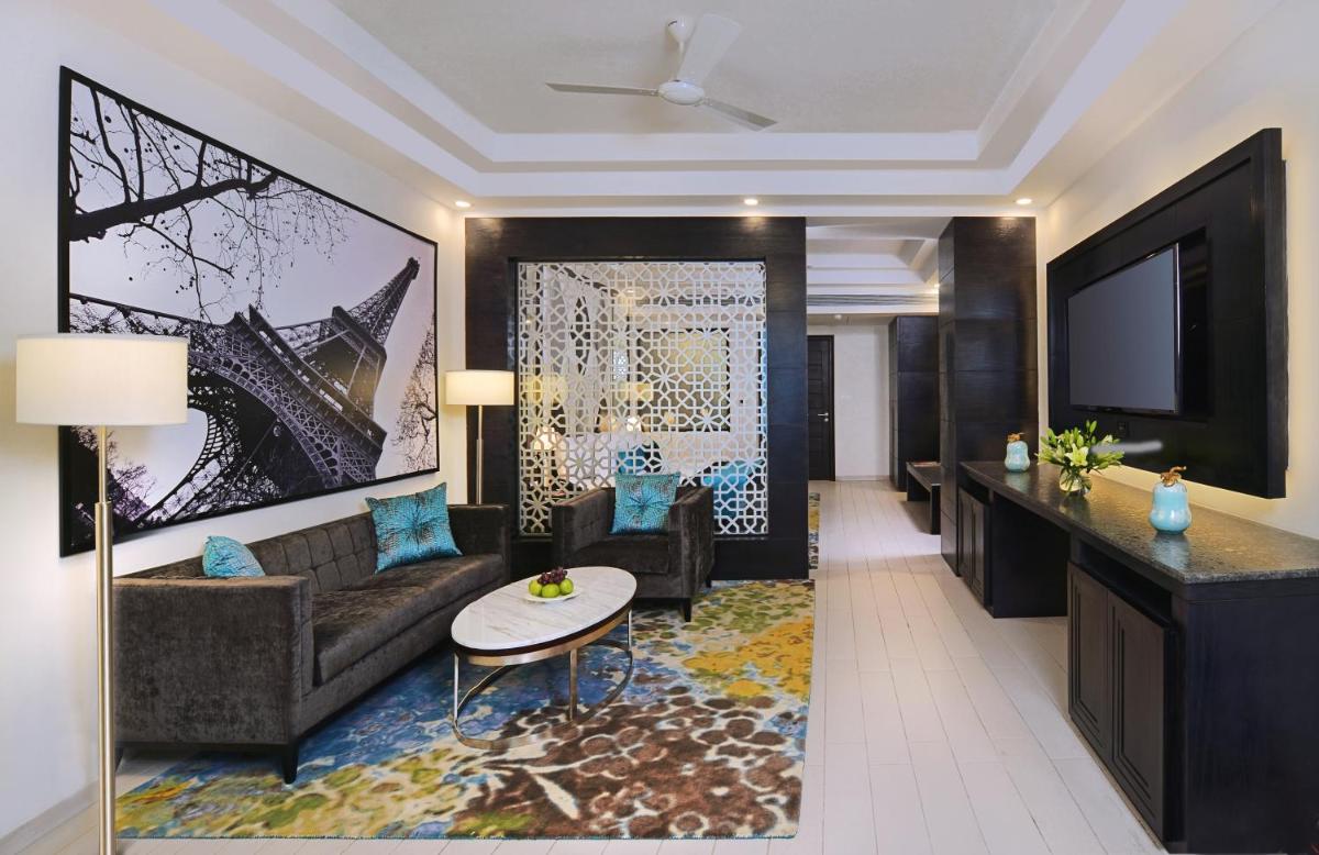 a living room with a couch and a tv at Radisson Chandigarh Zirakpur in Chandīgarh