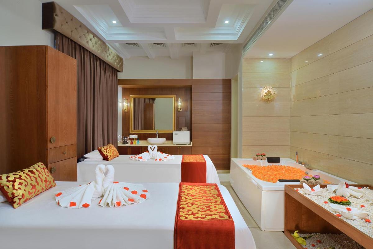 a hotel room with two beds and a mirror at Radisson Chandigarh Zirakpur in Chandīgarh