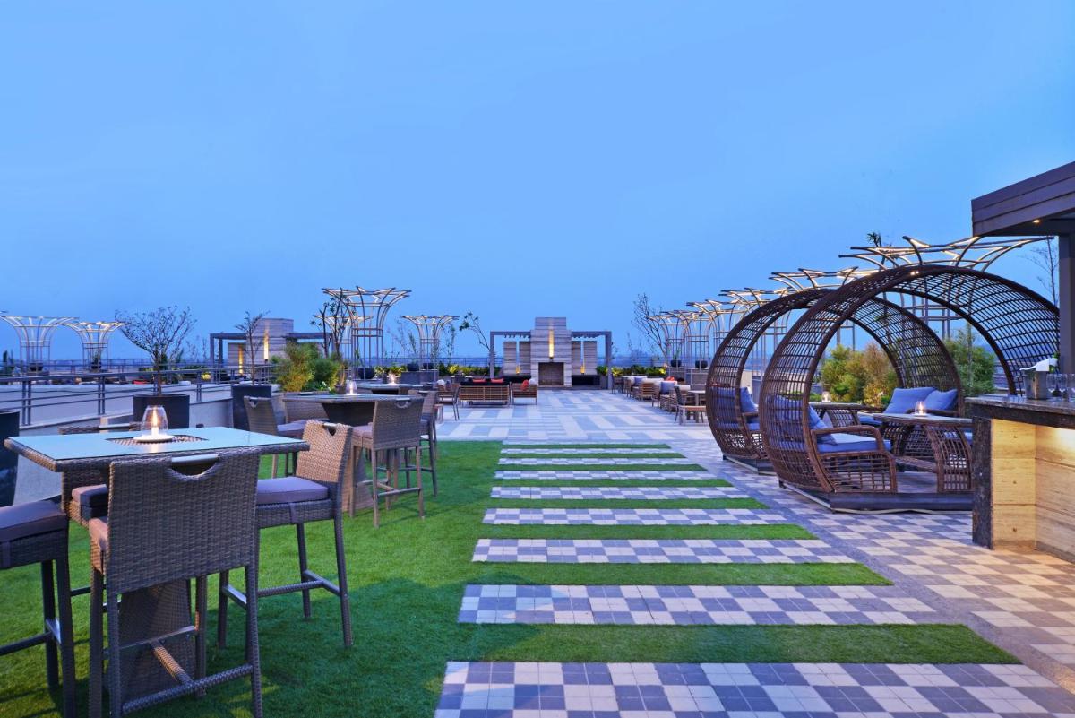 a patio with tables and chairs on a roof at Radisson Chandigarh Zirakpur in Chandīgarh