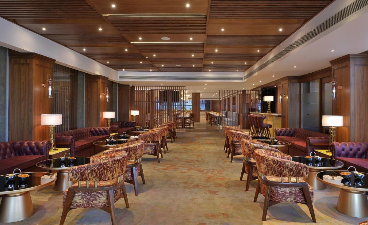 a hotel lobby with tables and chairs and tablesktop at Radisson Chandigarh Zirakpur in Chandīgarh