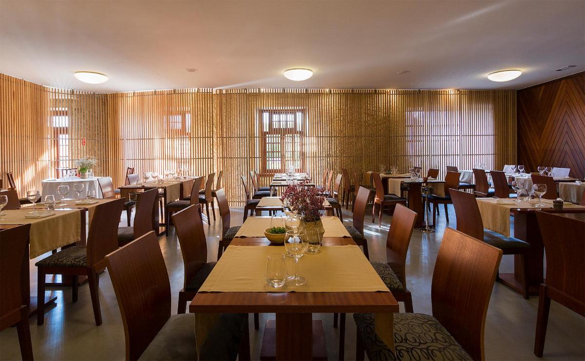 uma sala de jantar com mesas e cadeiras em um restaurante em Hotel Meira em Vila Praia de Âncora