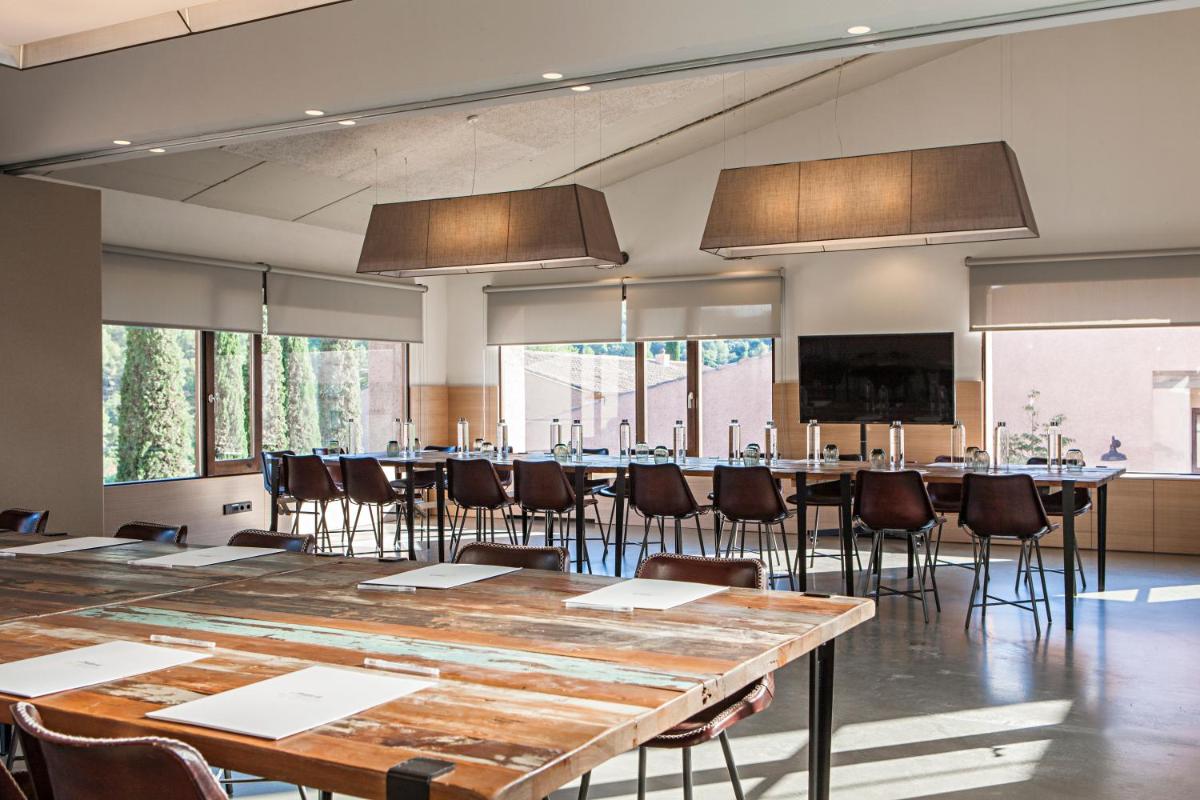 una sala de conferencias con una mesa grande y sillas en Terra Dominicata - Hotel & Winery - Adults Only, en Escaladei