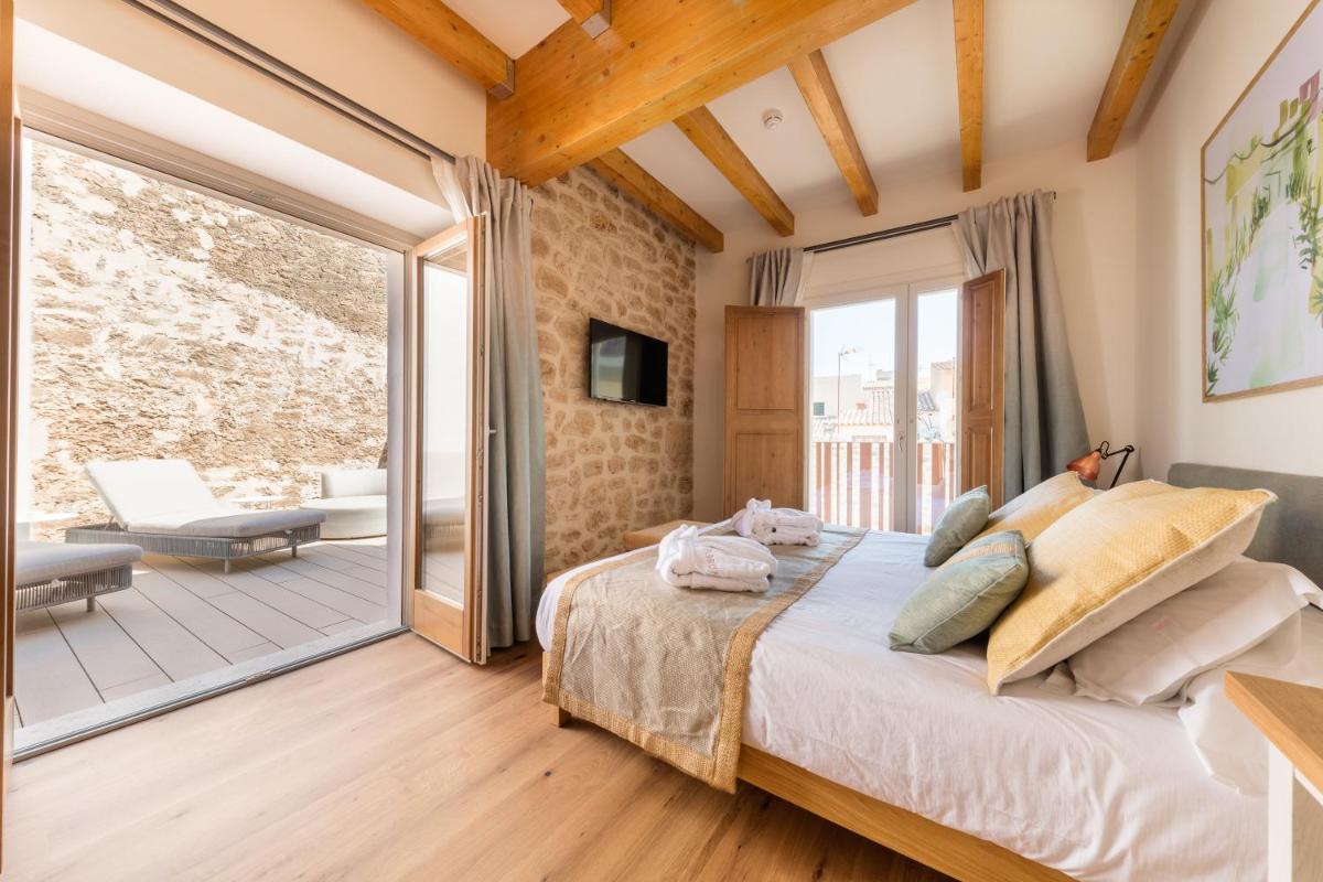 Un dormitorio con una cama grande y un balcón. en Forum Boutique Hotel & Spa - Adults Only, en Alcudia