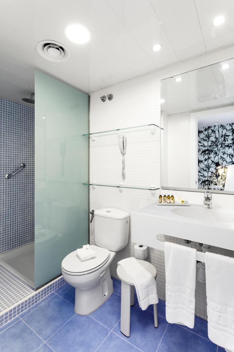Un baño con inodoro y ducha de cristal. en Hotel Anabel, en Lloret de Mar