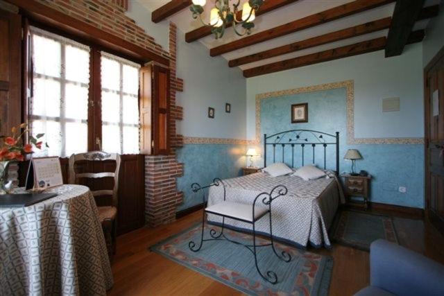1 dormitorio con 1 cama en una habitación con paredes azules en Hotel "Posada de Cantabria EL SOLAR" -Cenas típicas y Gintonic- Bar -Terraza panorámica, en Galizano