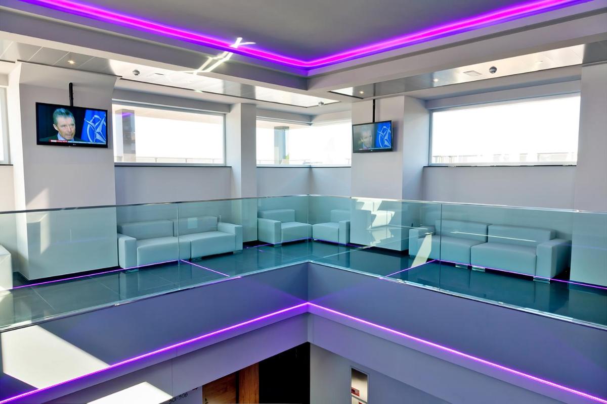 Habitación vacía con sillas azules e iluminación púrpura en Dña Monse Hotel Spa & Golf, en Torrevieja
