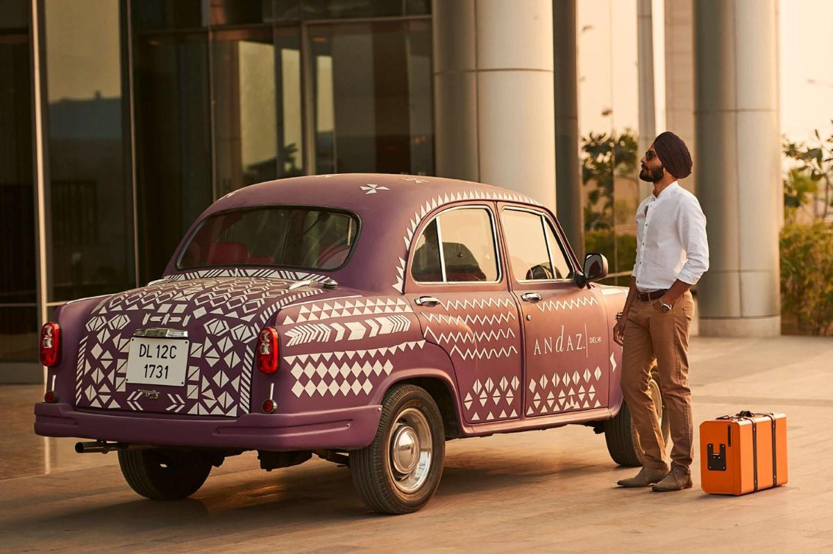 a man is standing next to a purple car at Andaz Delhi, by Hyatt in New Delhi a man is standing next to a purple car at Andaz Delhi, by Hyatt in New Delhi