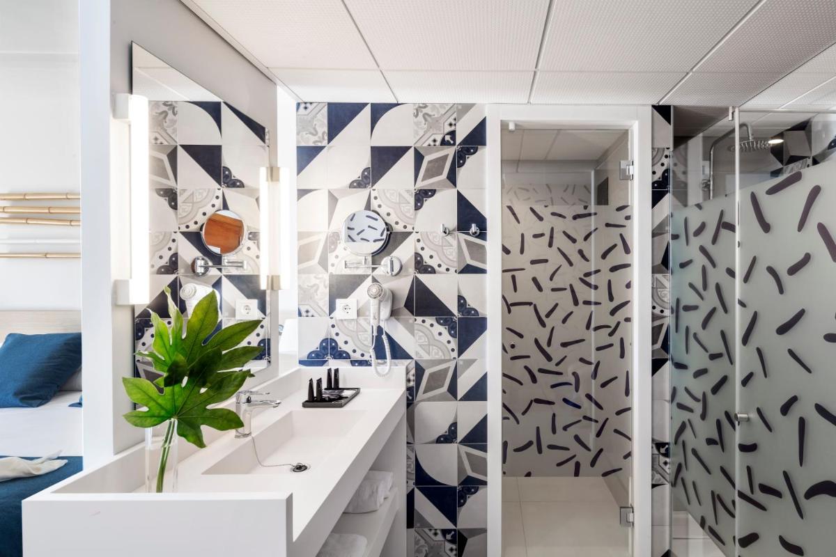 Baño con azulejos azules y blancos en la pared en AQUA Hotel Onabrava & Spa 4*Sup, en Santa Susanna Baño con azulejos azules y blancos en la pared en AQUA Hotel Onabrava & Spa 4*Sup, en Santa Susanna