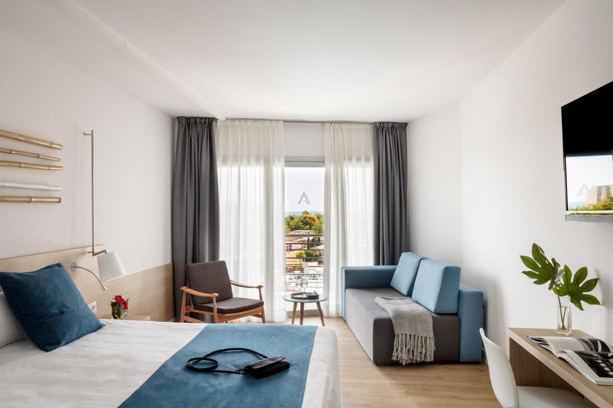 una habitación de hotel con una cama y un sofá en AQUA Hotel Onabrava & Spa 4*Sup, en Santa Susanna