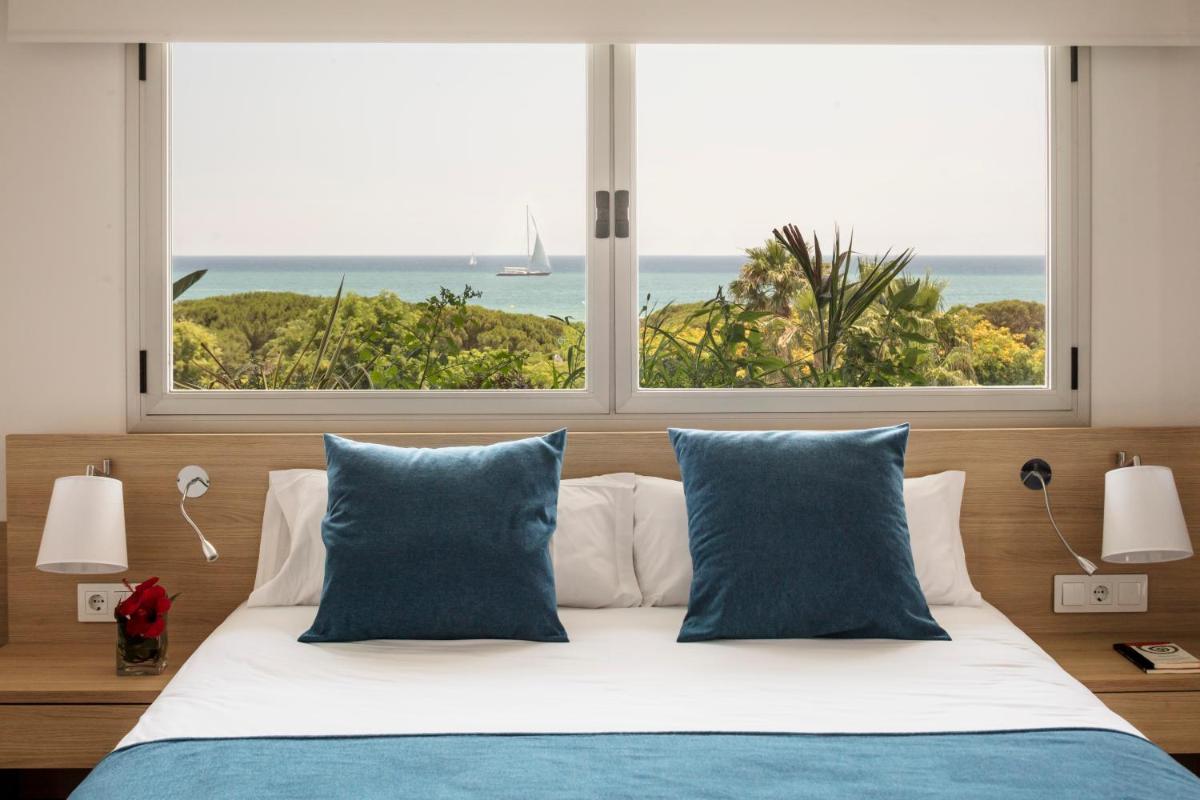 1 cama con almohadas azules y vistas al océano en AQUA Hotel Onabrava & Spa 4*Sup, en Santa Susanna 1 cama con almohadas azules y vistas al océano en AQUA Hotel Onabrava & Spa 4*Sup, en Santa Susanna
