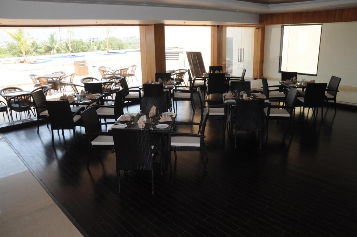 a dining room with tables and chairs and a projection screen at Fortune Select Grand Ridge, Tirupati - Member ITC Hotels' Group in Tirupati
