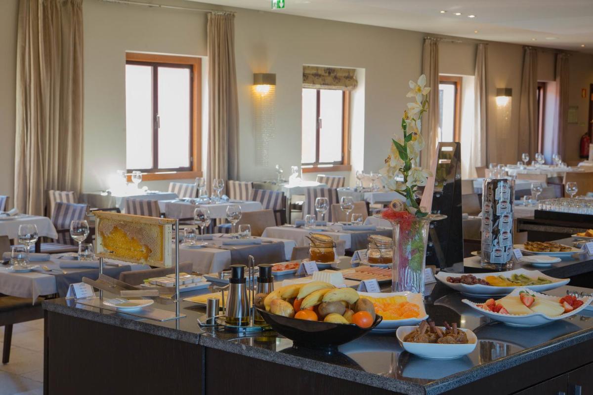 uma mesa com tigelas de comida em um restaurante em Your Hotel & Spa Alcobaça em Alcobaça