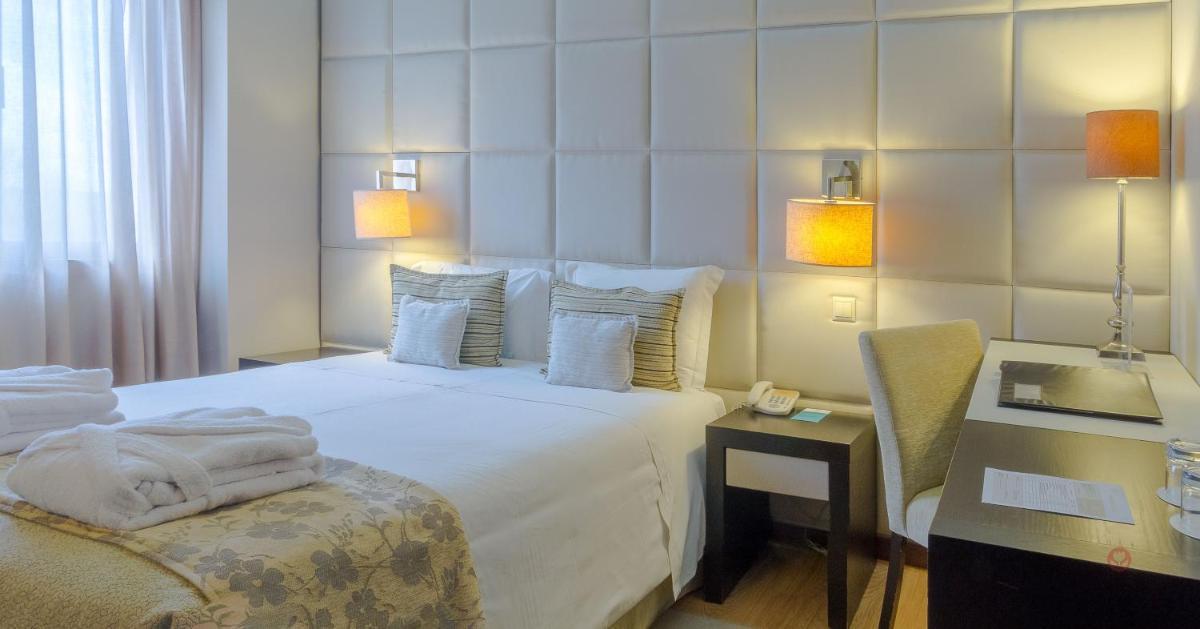 um quarto de hotel com uma cama, uma cadeira e uma escrivaninha em Your Hotel & Spa Alcobaça em Alcobaça