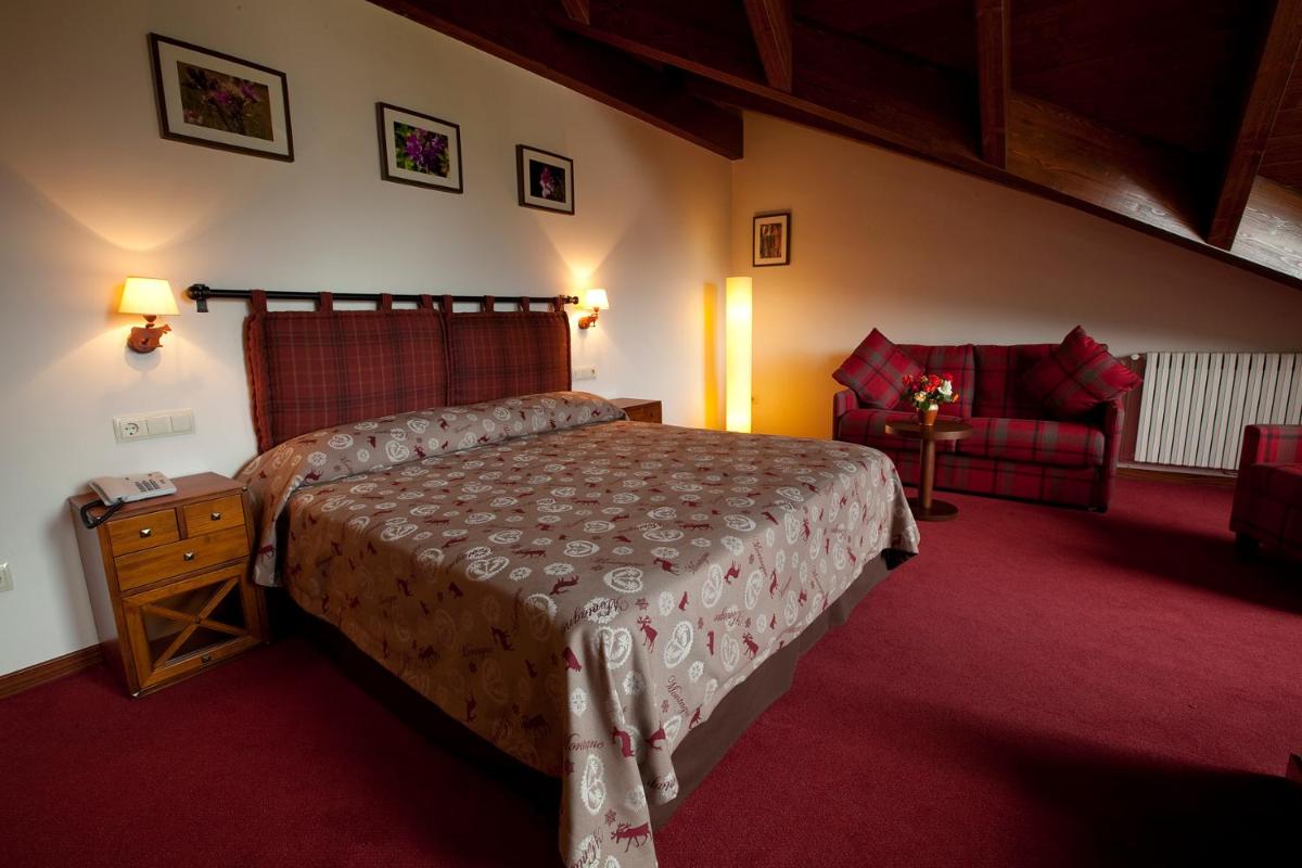 Un dormitorio con una cama grande y una silla. en Hotel La Morera, en Valencia de Aneu