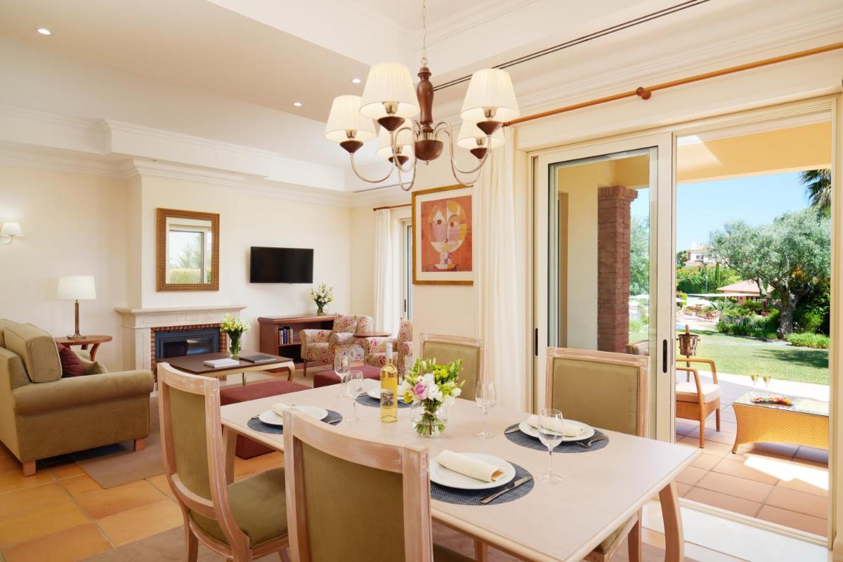 uma sala de jantar e sala de estar com mesa e cadeiras em Monte Rei Golf & Country Club em Vila Nova de Cacela