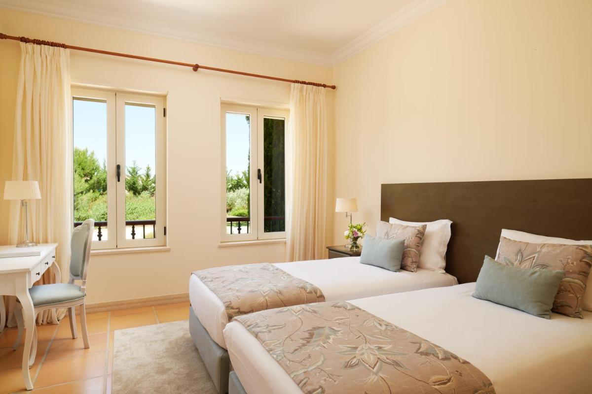 um quarto com 2 camas, uma secretária e janelas em Monte Rei Golf & Country Club em Vila Nova de Cacela mais 66 fotografias