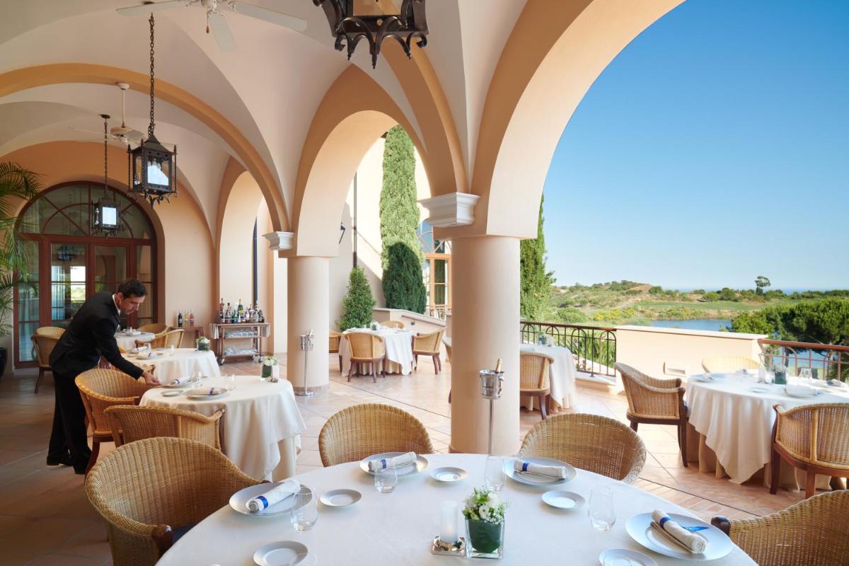 um homem sentado à mesa de um restaurante em Monte Rei Golf & Country Club em Vila Nova de Cacela