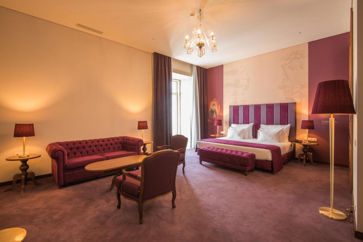 um quarto de hotel com uma cama e um sofá em Vila Gale Collection Braga em Braga