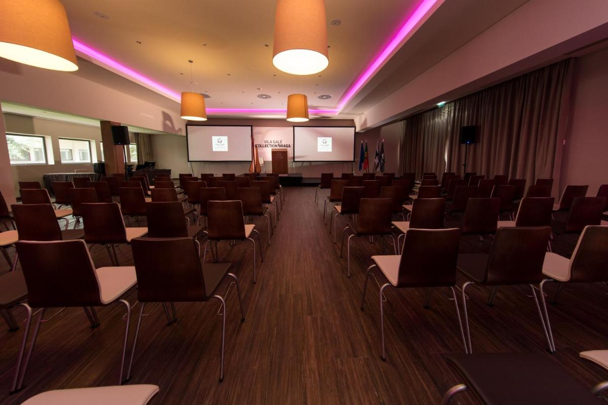 uma sala de conferências com cadeiras e um pódio em Vila Gale Collection Braga em Braga mais 54 fotografias
