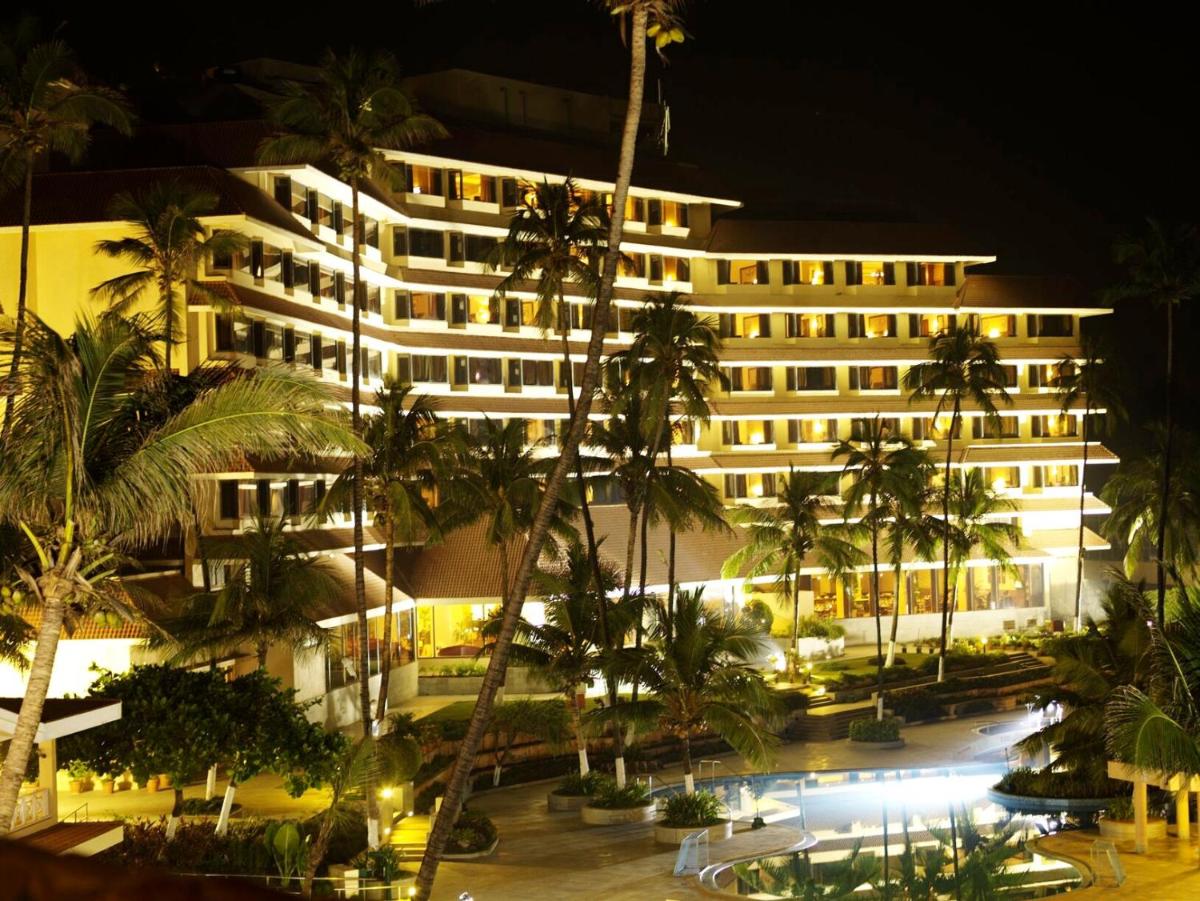 a view of a hotel at night with palm trees at The Retreat Hotel & Convention Centre in Mumbai