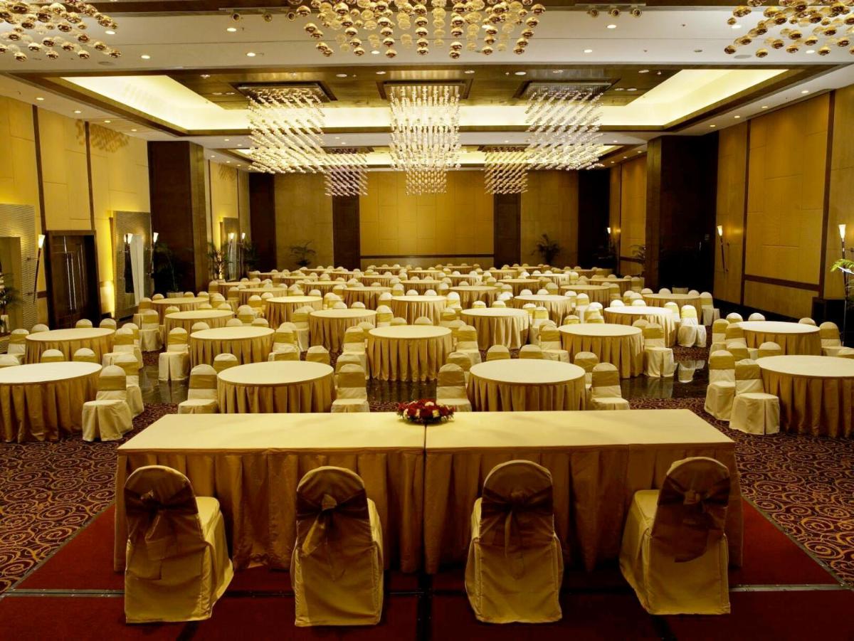 a large banquet hall with tables and chairs in it at The Retreat Hotel & Convention Centre in Mumbai