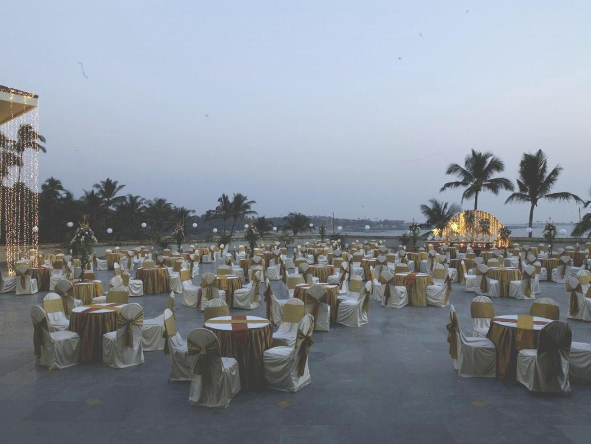 a large group of tables and chairs with palm trees at The Retreat Hotel & Convention Centre in Mumbai