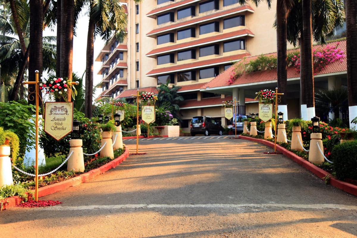 a road in front of a building with flowers at The Retreat Hotel & Convention Centre in Mumbai