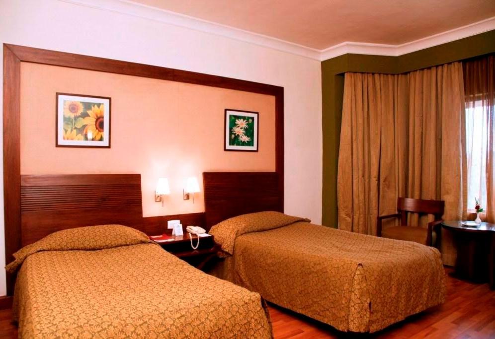 a hotel room with two beds in a room at The Retreat Hotel & Convention Centre in Mumbai