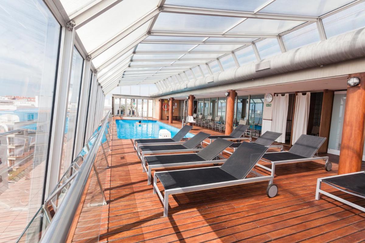 Un balcón con sillas y una piscina en un crucero. en ARTIEM Capri, en Mahón