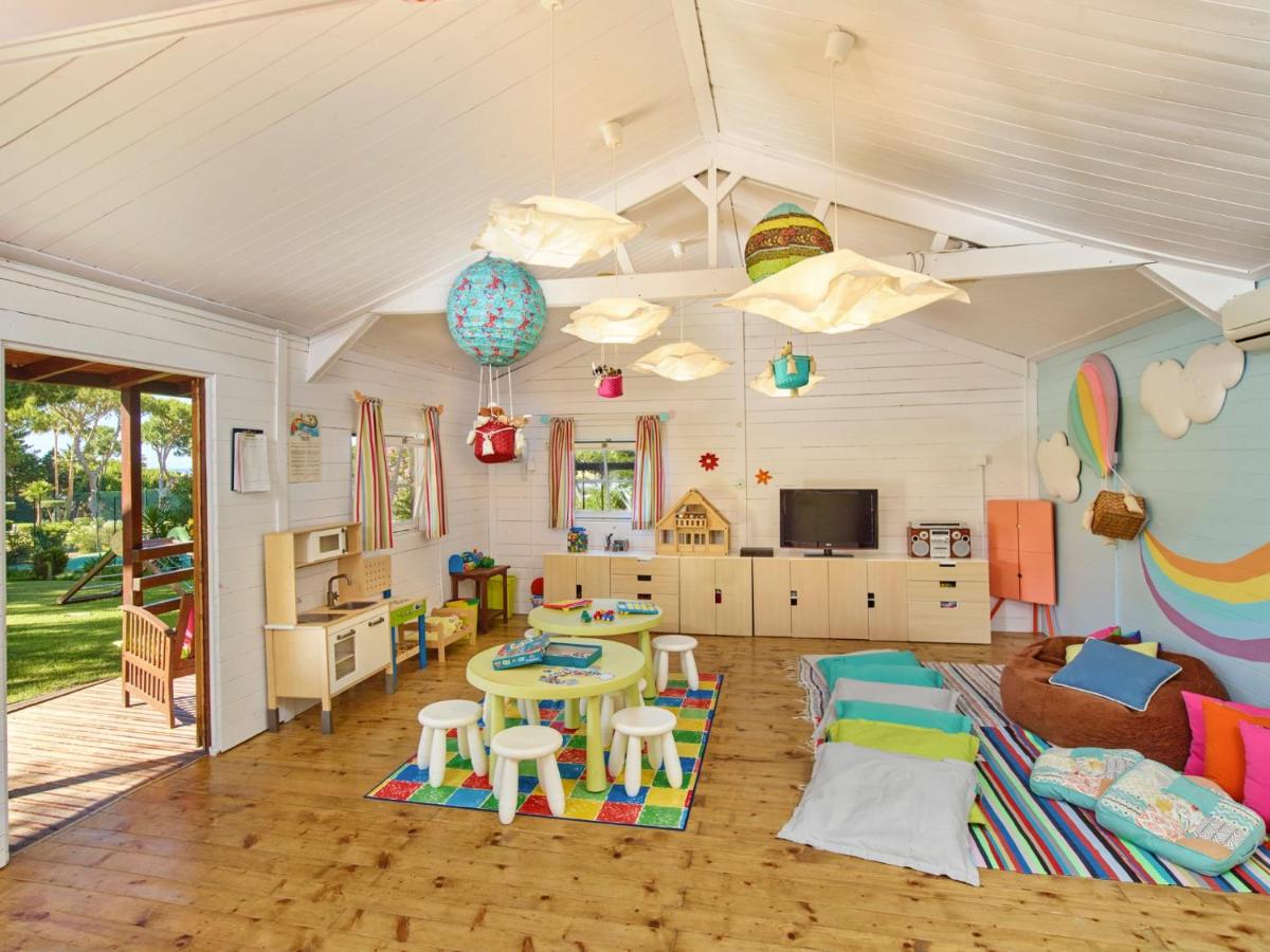 uma sala de estar com uma mesa e um quarto com uma cozinha em Hotel Quinta do Lago na Quinta do Lago