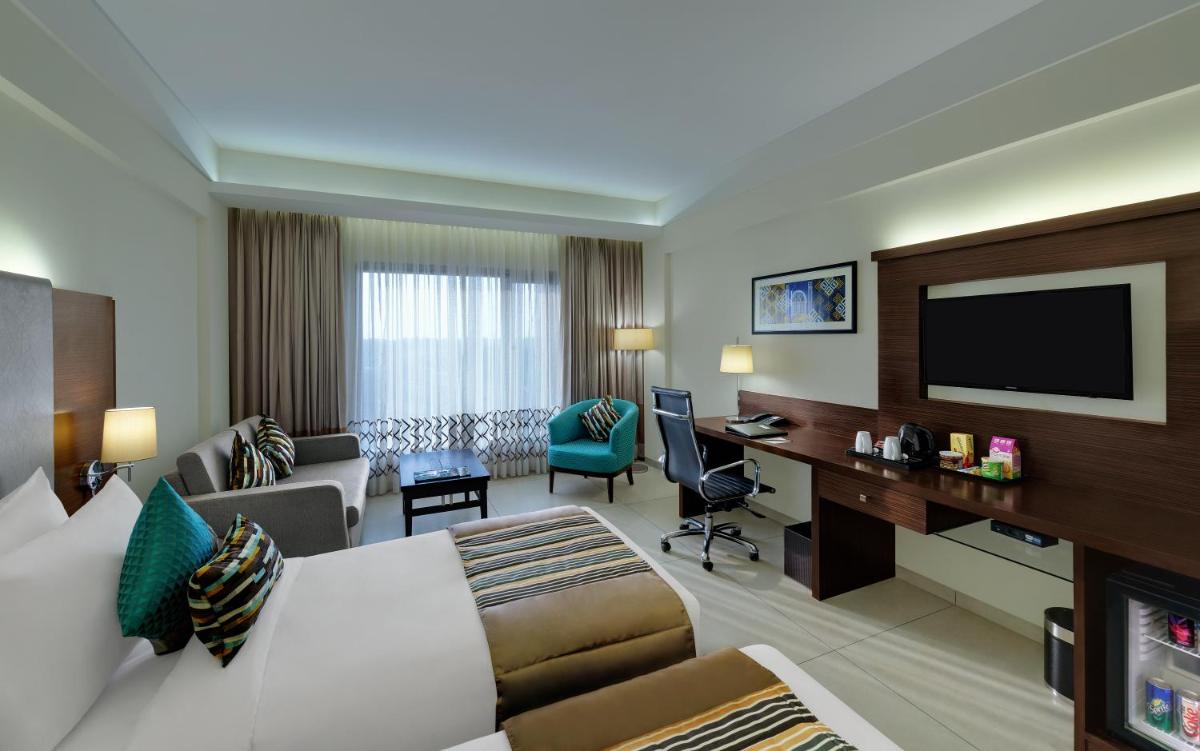 a hotel room with a bed and a desk at The Fern Kadamba Hotel And Spa in Old Goa