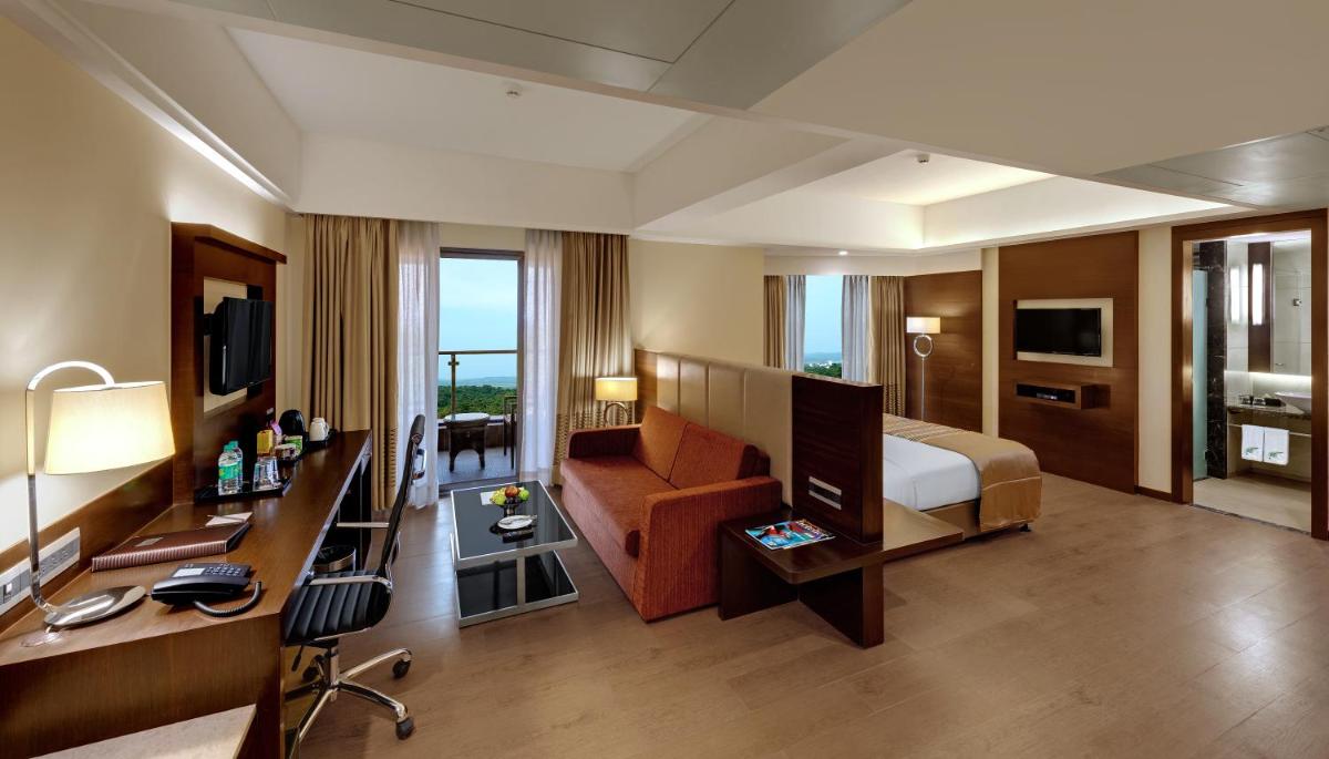 a hotel room with a bed and a desk at The Fern Kadamba Hotel And Spa in Old Goa