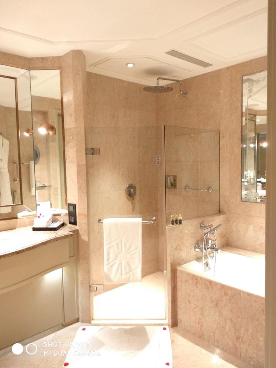 a bathroom with a shower and a tub and a sink at Taj Lands End in Mumbai a bathroom with a shower and a tub and a sink at Taj Lands End in Mumbai