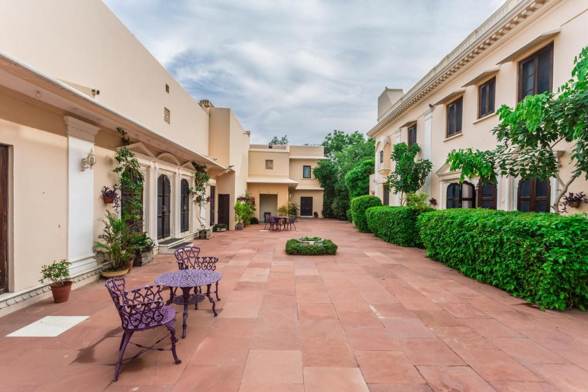 an empty courtyard of a building with chairs and tables at Royal Heritage Haveli - By Leisure Hotels in Jaipur