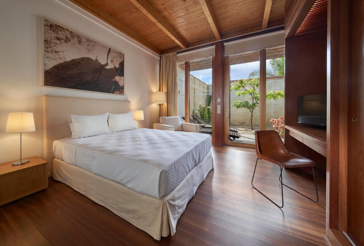 um quarto com uma cama e uma janela grande em Hotel Porto Santo & Spa em Porto Santo