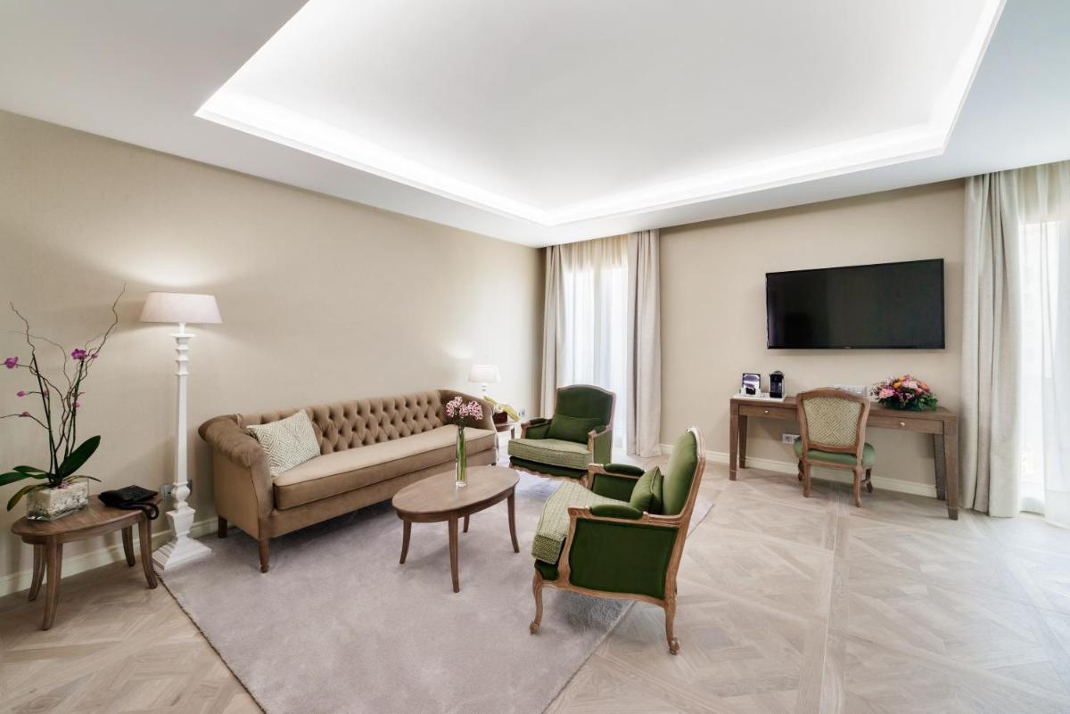 Una sala de estar con un sofá y sillas y un televisor. en Lamaro Hotel, en Barcelona