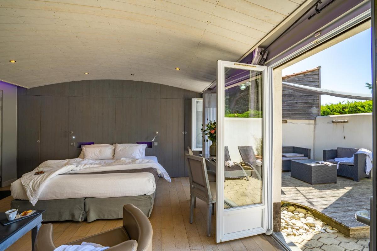Un ou plusieurs lits dans un hébergement de l'établissement Elégance Suites Hôtel