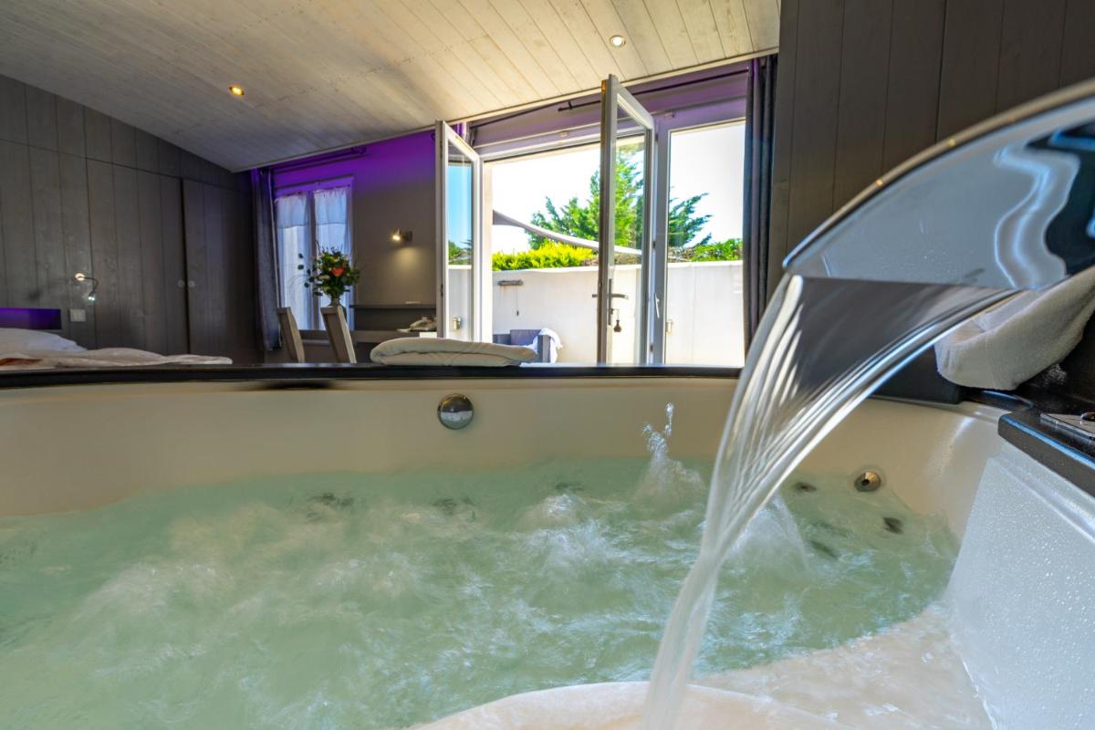 une baignoire avec une fontaine dans l'établissement Elégance Suites Hôtel, au Bois-Plage-en-Ré