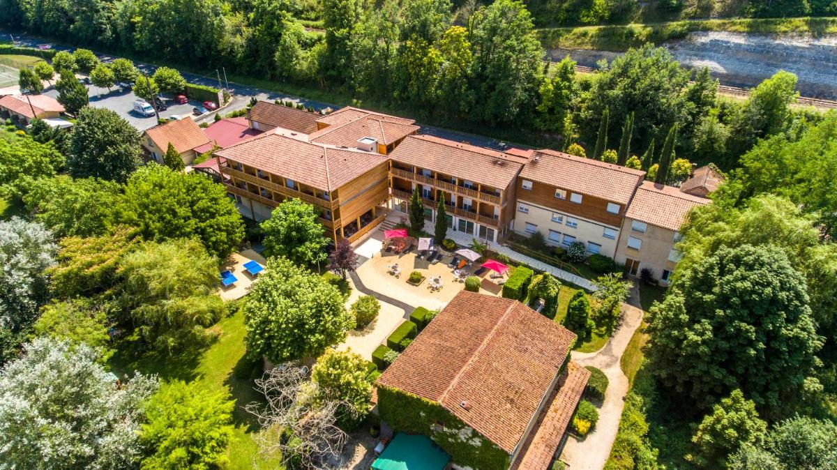 Elle offre une vue sur une grande maison dotée d'une piscine. dans l'établissement Auberge de la Petite Reine, à Siorac-en-Périgord