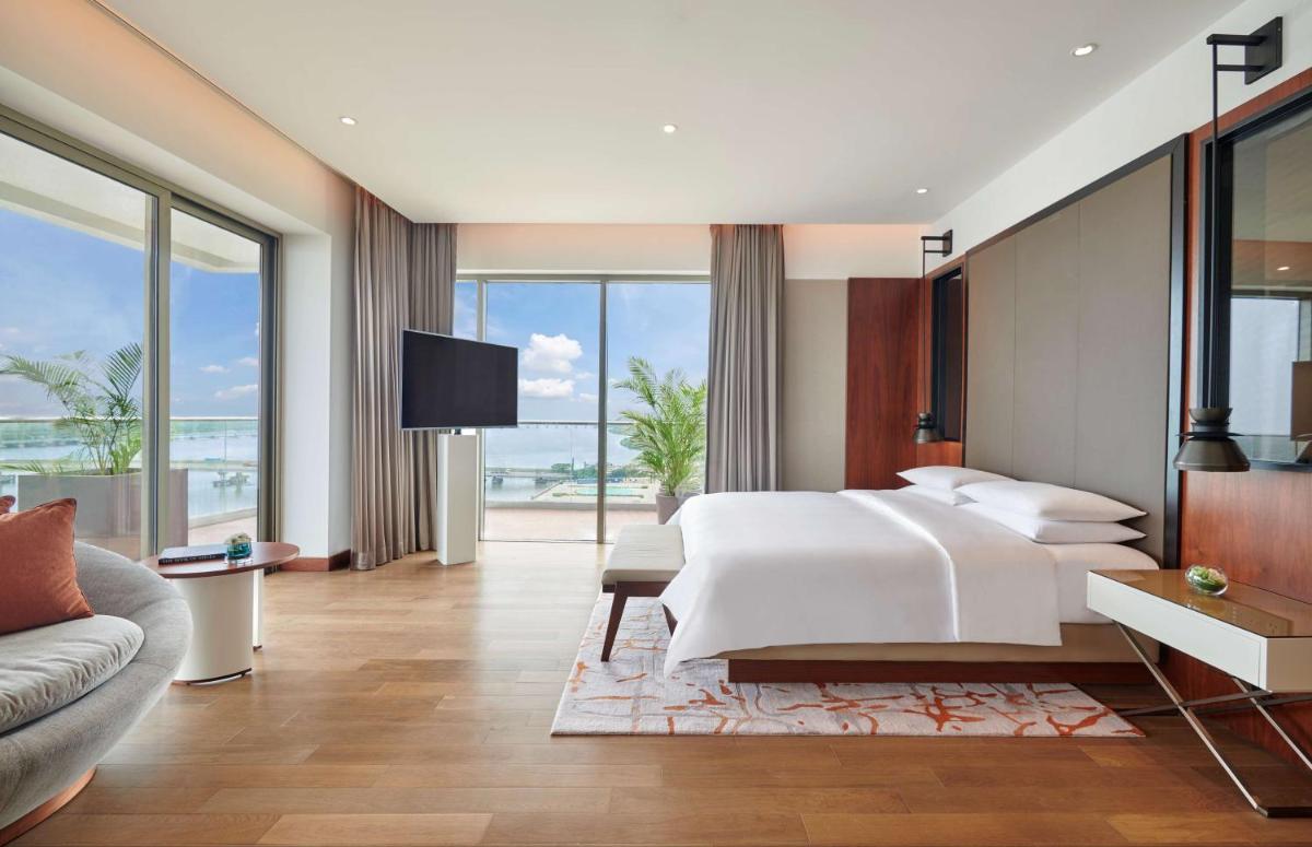 a bedroom with a large white bed and a couch at Grand Hyatt Kochi Bolgatty in Cochin
