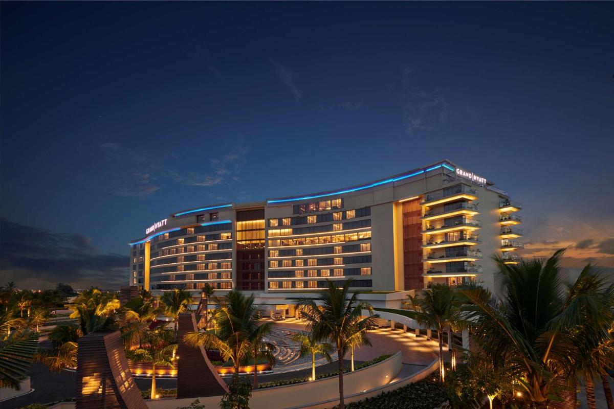a hotel building with palm trees at night at Grand Hyatt Kochi Bolgatty in Cochin