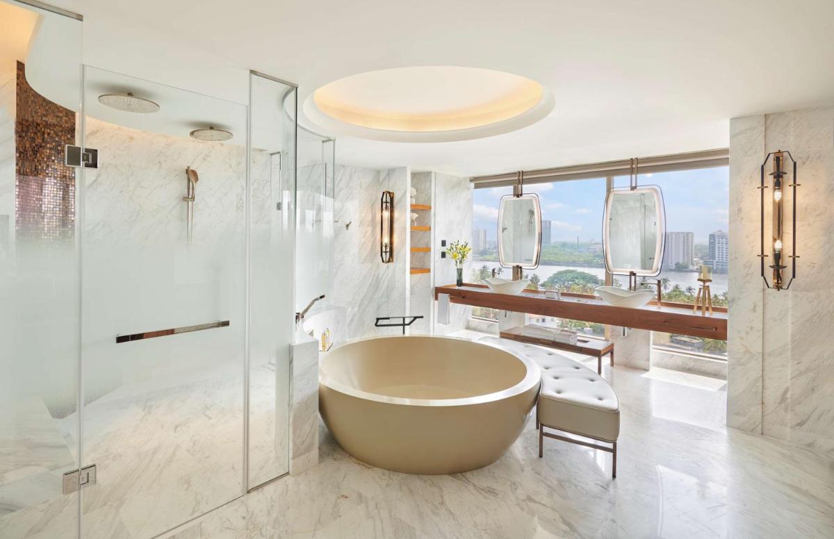 a bathroom with a tub and a shower and a sink at Grand Hyatt Kochi Bolgatty in Cochin