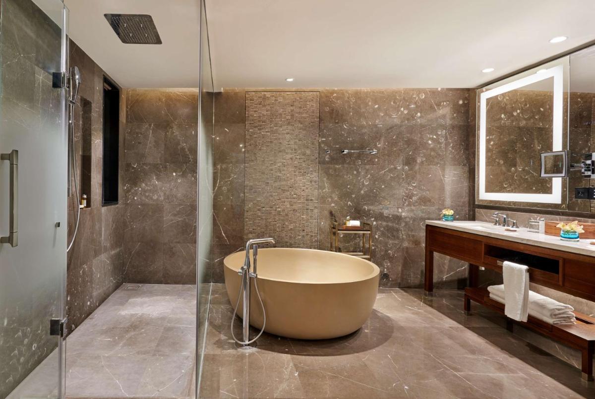 a bathroom with a tub and a sink at Grand Hyatt Kochi Bolgatty in Cochin