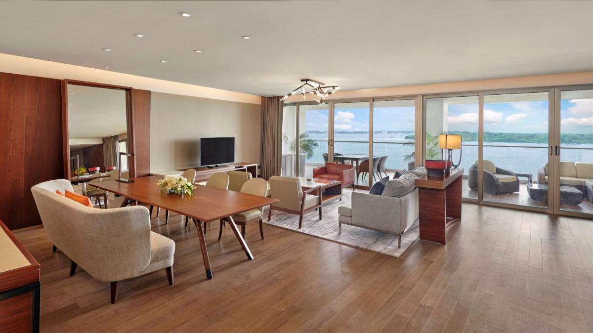 a living room with a table and chairs and a living room at Grand Hyatt Kochi Bolgatty in Cochin