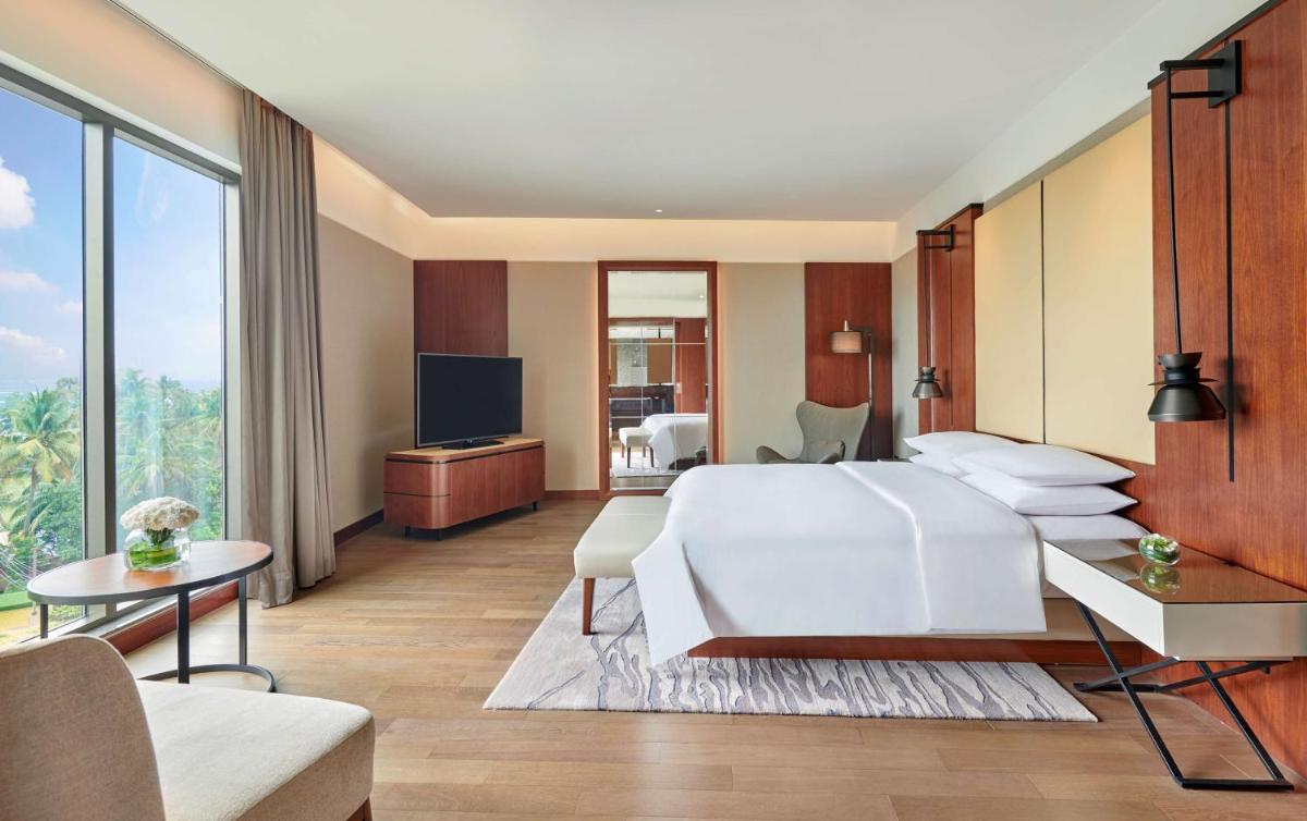 a hotel room with a bed and a television at Grand Hyatt Kochi Bolgatty in Cochin