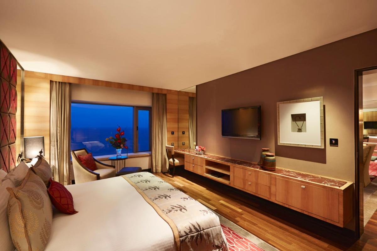 a hotel room with a large bed and a television at Taj Lands End in Mumbai a hotel room with a large bed and a television at Taj Lands End in Mumbai