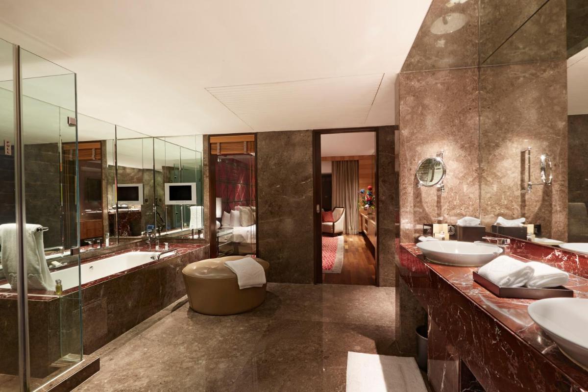 a bathroom with two sinks and a tub at Taj Lands End in Mumbai
