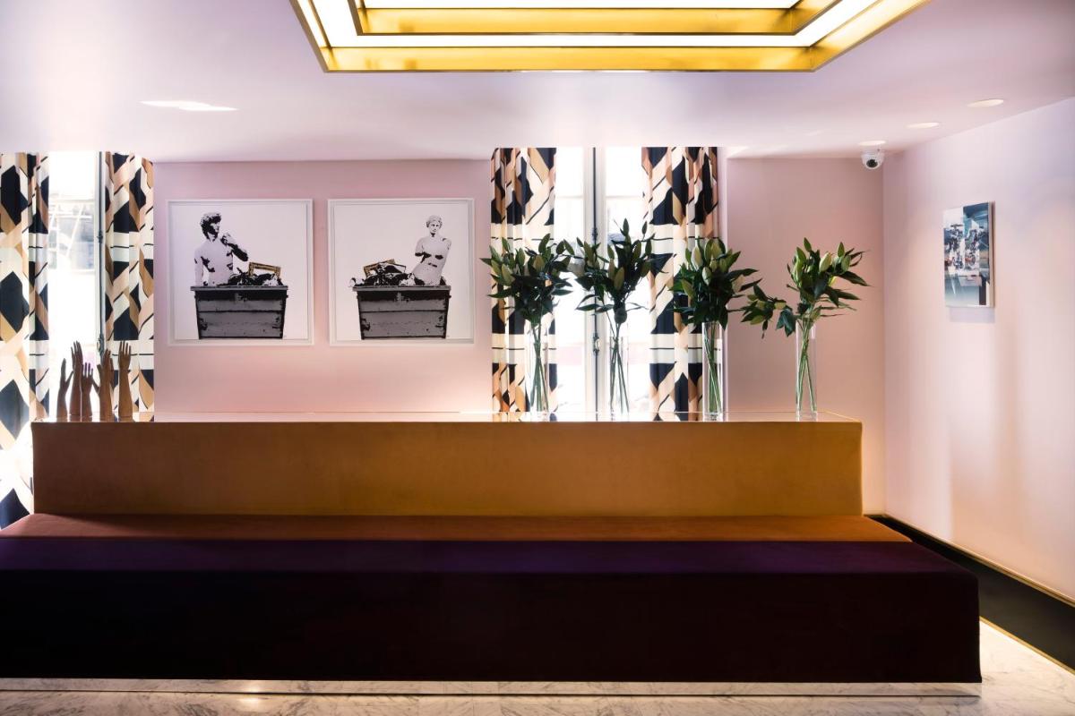 une salle d'attente avec des plantes sur le mur dans l'établissement Hôtel Saint-Marc, à Paris