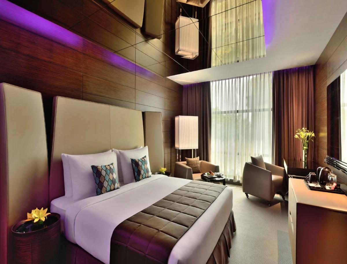 a bedroom with a large bed and a living room at Radisson Blu Atria Bengaluru in Bengaluru a bedroom with a large bed and a living room at Radisson Blu Atria Bengaluru in Bengaluru