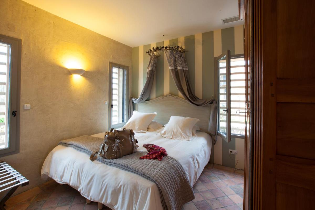 Un ou plusieurs lits dans un hébergement de l'établissement Hôtel-Spa Le Saint Cirq